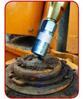 Pocket Size Grease Joint Rejuvenator with 5 Inch Flex-Hose unclogging a dirty fitting on industrial equipment