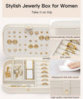 Open travel jewelry case for women on the go, showing double-layer design in beige PU leather with ring holders and dividers.