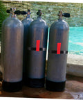 Four scuba tanks near a pool with Durable Side Mount Scuba Tank Strap Holder Built From Tough Rubber shown on two tanks.