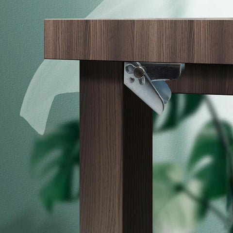 Close-up of Heavy Duty Folding Hinge Bracket Pair With Self Locking Design attached to a wooden table leg for secure support.