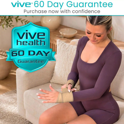 Woman wearing beige adjustable wrist wrap brace for carpal tunnel pain relief, seated on couch for all-day comfort and support