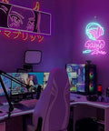 Close-up of gaming setup with purple lights, featuring a Game Zone neon sign and multiple monitors on a modern desk.
