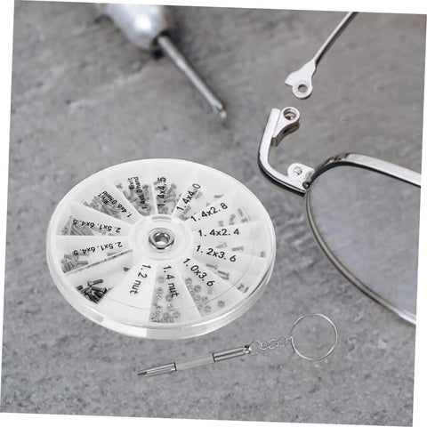 Eyeglass Repair Kit With Screws And Mini Screwdriver Components For Quick Fixes To Glasses Sunglasses And Watches Includes Convenient Round Storage Box And Travel Ready Assortment For Home Or On The Go on gray surface next to eyeglasses.