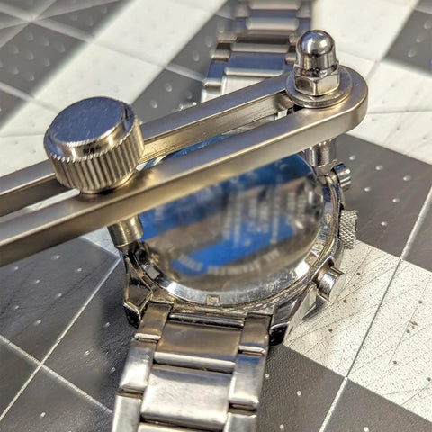 Adjustable Watch Back Remover Tool with Wrench Style Case Opener in use on metal watch for battery replacement