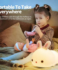 Lit Cute Bunny Night Light For Kids with 16 Colors Tap Control beside child playing in bedroom