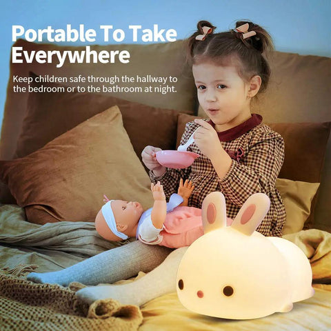 Lit Cute Bunny Night Light For Kids with 16 Colors Tap Control beside child playing in bedroom