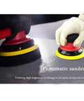Hands using Heavy Duty 5 Inch Random Orbital Palm Sander Dual Action Pneumatic Power Tool With Aluminum Body on surface