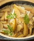Hase En Kamado San Earthenware Rice Pot with bamboo shoots and fern on top of rice, showcasing its use in Japanese cooking.