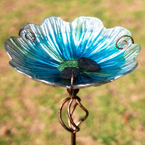 Close-up of blue glass bird bath and feeder with metal stake, four pronged stable base for yard and garden, 31 inch outdoor height.