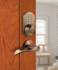 Electronic Touchpad Keyless Deadbolt And Passage Lever Combo In Antique Brass installed on a wooden door