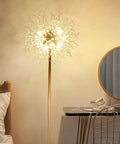 69 Inch Crystal Floor Lamp With K9 Crystals in a bedroom setting next to a dresser and chair, glowing with gold finish.