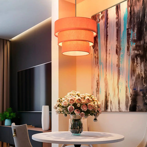 Orange Plug In Pendant Light With Three Tier Mid Century Modern Linen Shades hanging above a dining table with flowers.