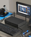 Rugged Fanless Mini Pc Built Tough For The Grind, Featuring Core I5 Processor, 8Gb Ram, 1Tb Ssd, Dual Lan, 12V To 24V Power, Perfect For Industrial Kiosks And Digital Signage Setup, with keyboard and monitor on a workspace.