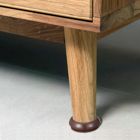 Light brown Felt Chair Leg Pads And Caster Cups Set For Hardwood Floors on wooden furniture leg, protecting against scratches.