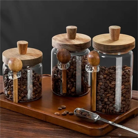 Go Ahead And Upgrade Your Countertop Setup With This Solid Clear Glass Storage Jar Featuring An Airtight Sealed Kitchen Canister And Wooden Spoon For Coffee Beans 900Ml Capacity Handles Dry Goods Smoothly And Looks Dope, displaying three jars with wooden lids and spoons on a wooden tray.