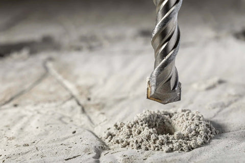 SDS Plus rotary hammer drill bit, carbide-tipped, 1/2 in x 18 in, close-up view above concrete dust