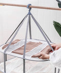 Three Tier Mesh Clothes Drying Rack With Foldable Sweater Hanger For Zero Sweat Quick Dry Setup And Hella Sturdy Heavy Duty Home Laundry Portable Solution with brown sweater.
