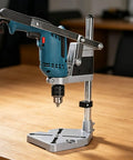 Versatile Drill Stand And Press Converter For Portable Drills mounted on a wooden table, showcasing steel build and dual hole support.