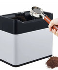 Electric Portafilter Cleaner With Compact Knock Box Designed To Swiftly Knock Out Spent Coffee Grounds Includes Three Heavy Duty Scrapers And One Precision Brush Fits Fifty One Or Fifty Eight Millimeter Baskets For Zero Sweat Maintenance, showing usage with a portafilter and grounds.