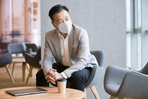 Person wearing Filtering Barrier Face Covering AFFM-5, sitting in office, demonstrating ASTM F3502-21 compliance