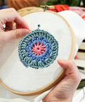 Hands using Six Piece Punch Needle Coaster Kit Set For Beginners And Adults, DIY Embroidery Craft with Patterns, Yarns, Hoop