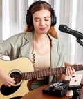 Woman playing guitar using Dual USB And XLR Dynamic Podcast Mic Kit With Volume Control Shock Mount And Pop Filter For Vocals Instruments Recording Voiceover And Live Streaming Right Now.