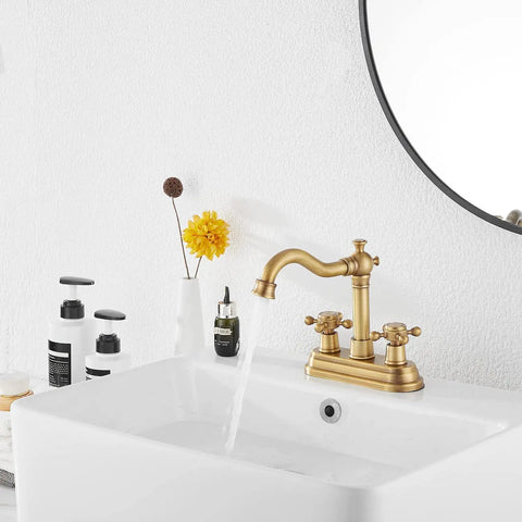 Antique Brass Two-Handle Four Inch Centerset Bathroom Faucet With 360 Degree Swivel High Arc Spout on white vanity sink