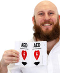 Man holding Two Sided Acrylic Aed Sign Built Hard As Nails To Help You Locate Life Saving Gear Fast With Heavy Duty Polished Wall Mount Display Featuring Bold Down Arrow Symbol Indoors Outdoors.