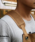 Close-up of man wearing Waxed Canvas Woodworking Apron For Men With 9 Tool Pockets Heavy Duty Carpenter Apron in workshop.