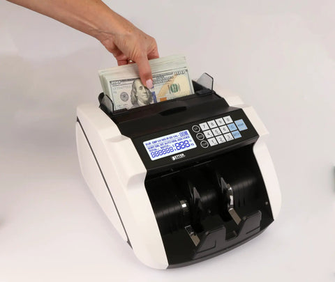 Hand placing bills into High Speed Money Counter With Multi Currency Detection, Counterfeit Bill Detector, LCD Display, 1000 Notes Per Minute