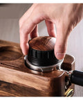 Hand using the Premium Coffee Distributor And Tamper Leveler for Home Baristas on a wooden espresso setup, 51mm.