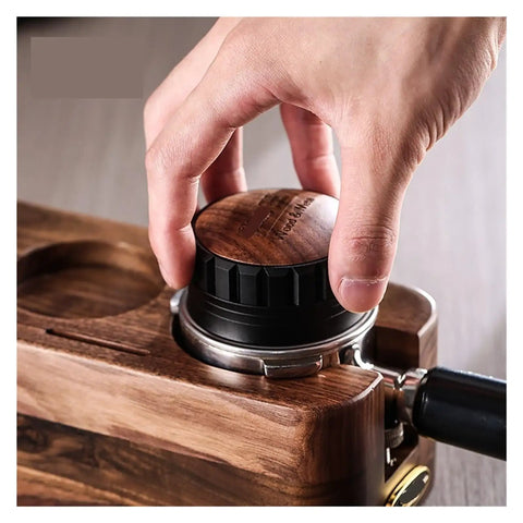 Hand using the Premium Coffee Distributor And Tamper Leveler for Home Baristas on a wooden espresso setup, 51mm.