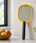Next Level Handheld Bug Zapper Racket With Batteries Included, Safe Three Layer Mesh resting against kitchen wall
