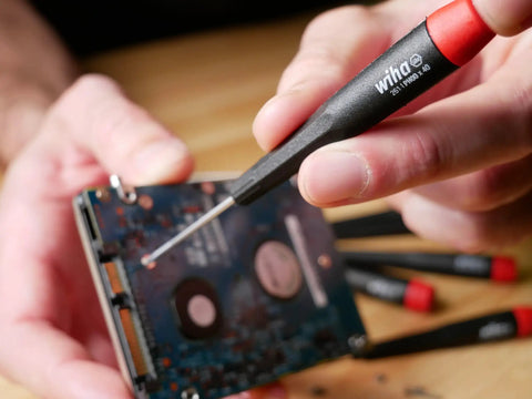 Using PicoFinish Mini Precision Screwdriver Set, 7-Piece Slotted And Phillips With Rotating Caps on electronics board.