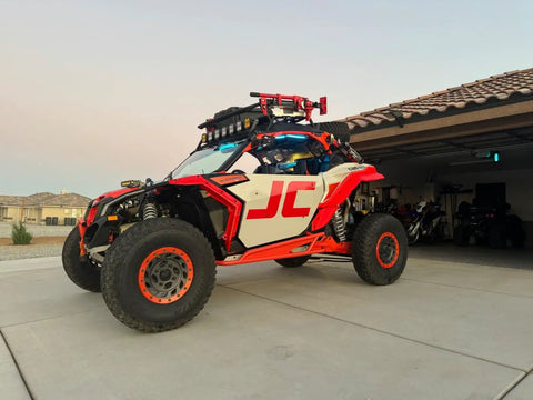 Red and white off-road vehicle with 33 Inch Ratcheting Off Road Utility Farm Jack 3 Ton Capacity attached on garage driveway
