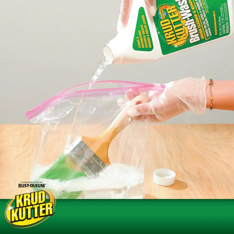 Gloved hand pouring brush wash cleaner into bag with paintbrush; Brush Wash Cleaner And Restorer For Latex And Oil Based Paint 32 Oz Liquid Cleaner