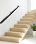 Kickass 7 Ft Indoor Stair Railing Featuring Matte Black Square Tube Handrail With Boss Level Non Slip Grip For Wall Mount Setup Totally Secure For Bathrooms Lofts And Kitchen Steps Rock Solid 500 Lb Rating mounted on a wall beside wooden stairs.