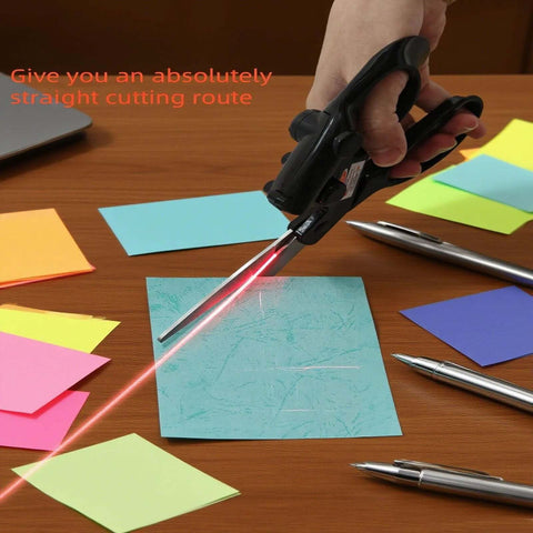 Laser-guided fabric scissors with stainless blades, handheld; cutting blue sticky note with red laser line visible.