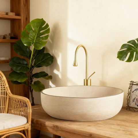Retro Oval Ceramic Vessel Sink for Bathroom Vanity, modern minimalist oval sink on wooden counter with brass faucet and greenery.