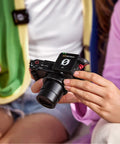 Person holding a camera with Plug-And-Play Ultra Compact Wireless Microphone System With Built-In Mics, GainAssist Technology, and 100m Range.