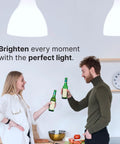 Two people toasting under bright Compact CFL Light Bulbs T2 Spiral 23W 1520 Lumens Daylight 5000K E26 lighting in a kitchen.