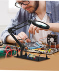 Man using Six Piece Flexible Third Hand Soldering Tool Set With Adjustable Arms PCB Holder And Magnifying Lamp for electronics.