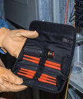 Person holding insulated 8 in 1 screwdriver set with interchangeable blades for electrical and general repairs in durable pouch.