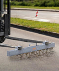 Absolute Beast 93 Pound Hanging Magnetic Sweeper Mounts To Forklifts and Overhead Rigs Heavy Duty Metal Pickup Tool cleaning debris on a road.