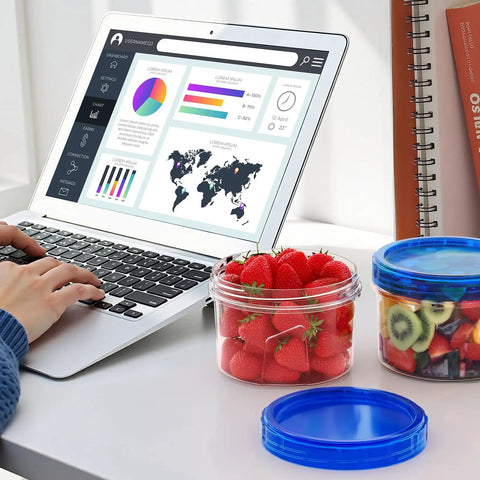 Sixteen Ounce Freezer Storage Containers Set With Twist Top Lids filled with strawberries and kiwi near laptop