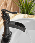 Oil Rubbed Bronze Waterfall Bathroom Sink Faucet With Single Handle 1 Hole Mount in use with clear water stream.