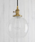 Dope Industrial Brass Pendant Light With 7.9 Inch Clear Glass Shade, Vintage Vibe Hanging Lamp, warm gold finish hanging in a room
