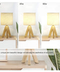 Set Of 2 Cute Wooden Tripod Bedside Lamps With Linen Fabric Shade, shown in three light intensities on a wooden table