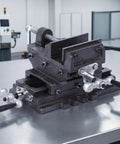 Heavy Duty Etyldya 5 Inch Bench Vise With Cross Slide For Milling & Drilling Press on steel workbench with dual knobs.