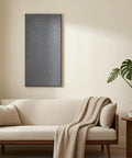 Six Piece Set Of Black Acoustic Wall Panels With Textured Felt Finish mounted on wall above beige sofa in modern living room.